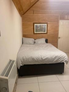 um quarto com uma cama e uma parede de madeira em Parkview em Hoo