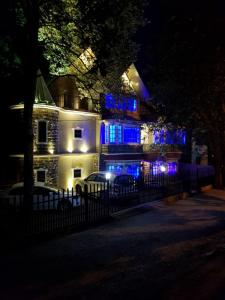 budynek z niebieskimi światłami w nocy w obiekcie Cherry Blossom w mieście Nainital