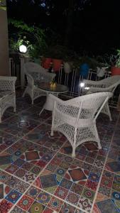 a patio with chairs and tables on a tiled floor at Cherry Blossom in Nainital