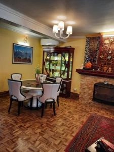 a dining room with a table and chairs and a fireplace at Cherry Blossom in Nainital