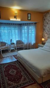 sypialnia z łóżkiem, 2 krzesłami i stołem w obiekcie Cherry Blossom w mieście Nainital