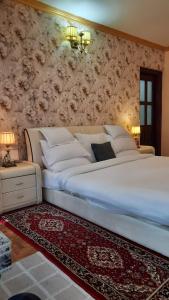 a bedroom with a large white bed with a floral wall at Cherry Blossom in Nainital