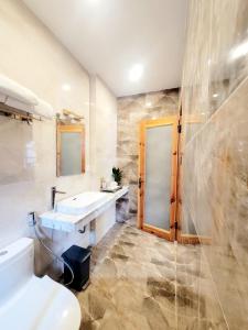 a bathroom with a sink and a shower and a toilet at Thung Lũng Kim Khuê Villas in Da Lat