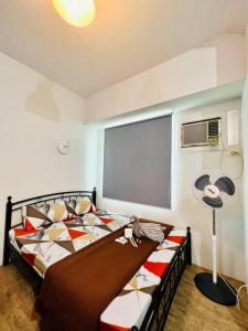 um quarto com uma cama, uma janela e uma ventoinha em Sweet Home with WiFi and Netflix em Manila