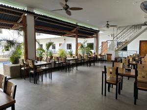 una sala da pranzo con tavoli, sedie e scale di MGH Alona Resort a Panglao