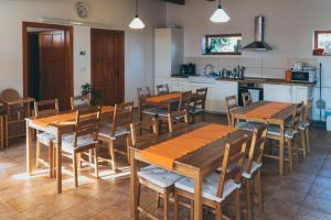 a room with wooden tables and chairs in a kitchen at Kun Pista Vendégház II in Vértesboglár +11 photos