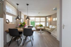a dining room and living room with a table and chairs at Vakantiewoning Domburg dichtbij strand, Kanonweistraat 12a in Domburg +20 photos