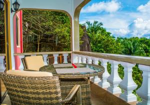 einen Balkon mit einem Tisch und Stühlen sowie Aussicht in der Unterkunft Les Elles Guesthouse Self Catering in Baie Lazare, Insel Mahé
