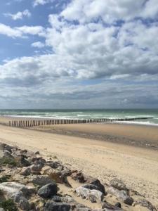 einen Strand mit Felsen und dem Meer an einem wolkigen Tag in der Unterkunft Vue sur dunes ! in Sangatte