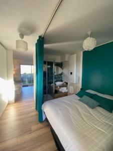 ein Schlafzimmer mit einer grünen Wand und einem Bett in der Unterkunft Vue sur dunes ! in Sangatte