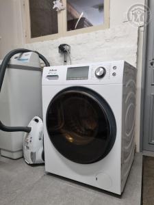 een wasmachine naast een droger bij Gîte & SPA Les Hirondelles de 2 à 8 personnes in Arnèke