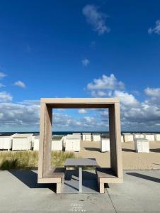 a bench in front of a mirror on the beach at Vue sur dunes ! in Sangatte