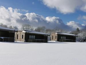 two buildings in the snow with snow covered ground at ACS in Bagnols