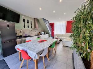 een keuken met een tafel met stoelen en een koelkast bij Gîte & SPA Les Hirondelles de 2 à 8 personnes in Arnèke