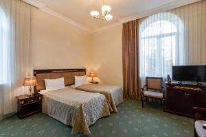 a hotel room with two beds and a flat screen tv at Jermuk Olympia Sanatorium in Jermuk