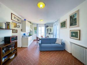 a living room with a blue couch and a kitchen at Appartamento Laura in Portoferraio