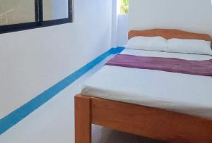 a bedroom with a bed with a blue line around it at RedDoorz @ SCJS INN Buug Sibugay in Buug