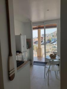 Il dispose d'un balcon et d'une cuisine avec un comptoir et une table. dans l'établissement Studio neuf atypique centre ville Palavas vue mer, à Palavas-les-Flots