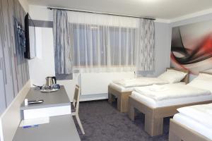 Habitación de hotel con 2 camas y escritorio en Penzion Vrtule, 