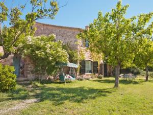 uma casa de pedra com um baloiço no quintal em Masia Vilatersana em Sant Llorenc Savall