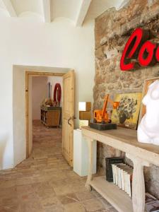 Habitación con pared de piedra y mesa de madera. en Masia Vilatersana, en Sant Llorenç Savall