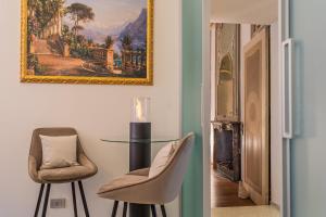 una habitación con una mesa y dos sillas y una pintura en Rovelli 41 by Rent All Como, en Como