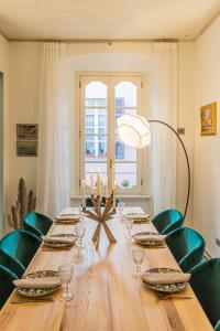 mesa de comedor con sillas verdes y lámpara en Rovelli 41 by Rent All Como, en Como