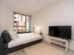 a bedroom with a bed and a flat screen tv at Pass the Keys Spacious Bright Flat 20 Mins To Central London in London