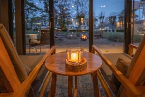 eine Kerze auf einem Tisch in einem Zimmer mit Stühlen in der Unterkunft SAND Lifestylehotel in Timmendorfer Strand