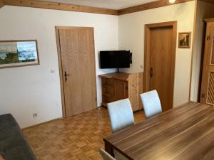 - un salon avec une table, des chaises et une télévision dans l'établissement Apartment Haus Dengg, à Mauterndorf
