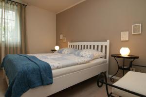 una camera da letto con un letto con una coperta blu e due tavoli di Meer Residenz Warnemuende a Warnemünde