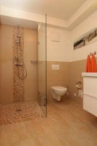 瓦爾內明德的住宿－Meer Residenz Warnemuende，一间带卫生间和玻璃淋浴间的浴室