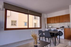 uma sala de estar com uma mesa e uma grande janela em Phaedrus Living: City Flat Palas 103 em Pafos