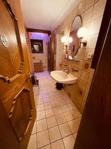 uma pequena casa de banho com um lavatório e um espelho em Haus an der Planai (Pistenzugang & Panoramablick) em Schladming