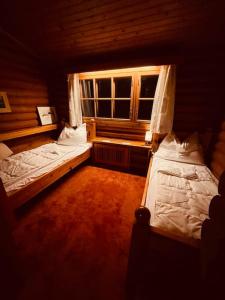 two beds in a room with a window at Haus an der Planai (Pistenzugang & Panoramablick) in Schladming