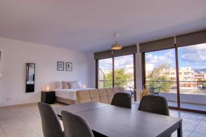 uma sala de estar com uma cama, uma mesa e cadeiras em Phaedrus Living: City Flat Palas 103 em Pafos
