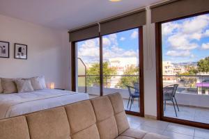 um quarto com uma cama e vista para uma varanda em Phaedrus Living: City Flat Palas 103 em Pafos