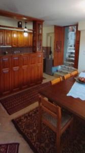 a kitchen with wooden cabinets and a wooden table at Ξενώνας Ερυκίνη in Dhímitra