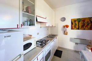 una cucina con piano cottura e forno a microonde di Appartamento Belvedere a Bagnaia a Rio nellʼElba