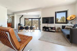 a living room with a couch and a tv at Luxury Sitges Hills Villa in Olivella