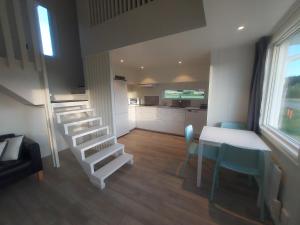 a living room with a staircase and a table and chairs at Havsnära Stuga in Klövedal