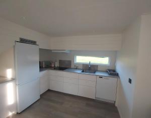 a kitchen with a white refrigerator and a sink at Havsnära Stuga in Klövedal