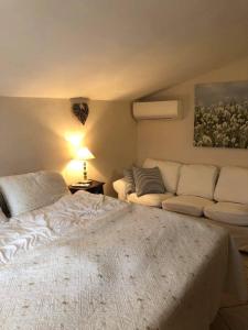 ein Schlafzimmer mit einem großen Bett und einem Sofa in der Unterkunft La Famiglia in Vasanello