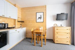 考斯賽力克的住宿－Dom na Wierchu，厨房配有桌椅和电视。