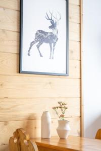 a picture of a deer on a wall with a table at Dom na Wierchu in Kościelisko