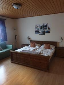 een slaapkamer met een groot bed en een bank bij Ferienwohnung Hohengaßner in Mariapfarr