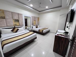 a hotel room with two beds and a flat screen tv at Hotel Sehmi's Best Rest Inn in Amritsar