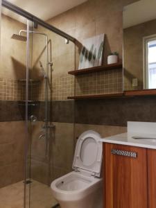 Adria Residences - Ruby Garden - 2 Bedroom for 4 person في مانيلا: حمام مع مرحاض ودش زجاجي