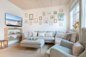 a living room with two couches and a tv at NEU! Ferienhaus Watt'n Glück Sylt in Westerland