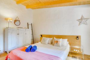 a bedroom with a bed with blue slippers on it at Ses Salines Terrace Home in Ses Salines